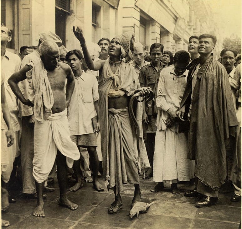 A Snake Charmer Doing His Best to Coax a Balcony Audience to Toss Down Some Money