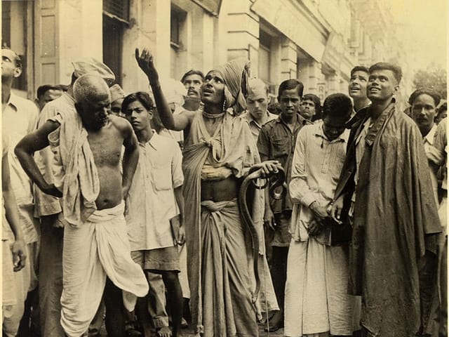 A Snake Charmer Doing His Best to Coax a Balcony Audience to Toss Down Some Money